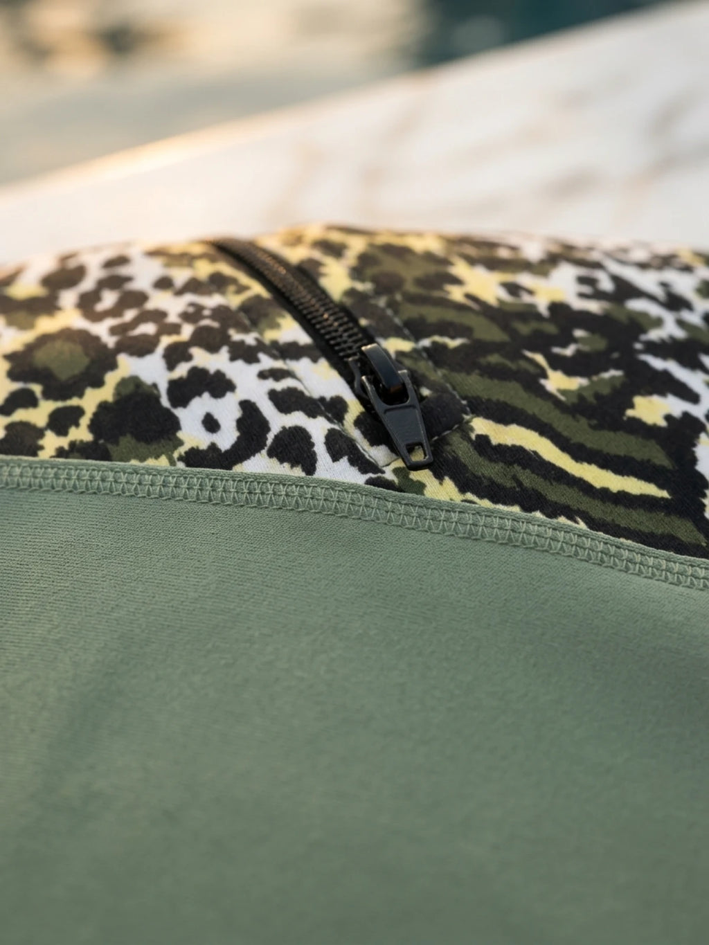 Adaçayı yeşili ve leopar desenli asimetrik detaylı tam kapalı tesettür mayo; uzun kollu fermuarlı tunik, boru paça pantolon ve uyumlu boneden oluşan üçlü set.